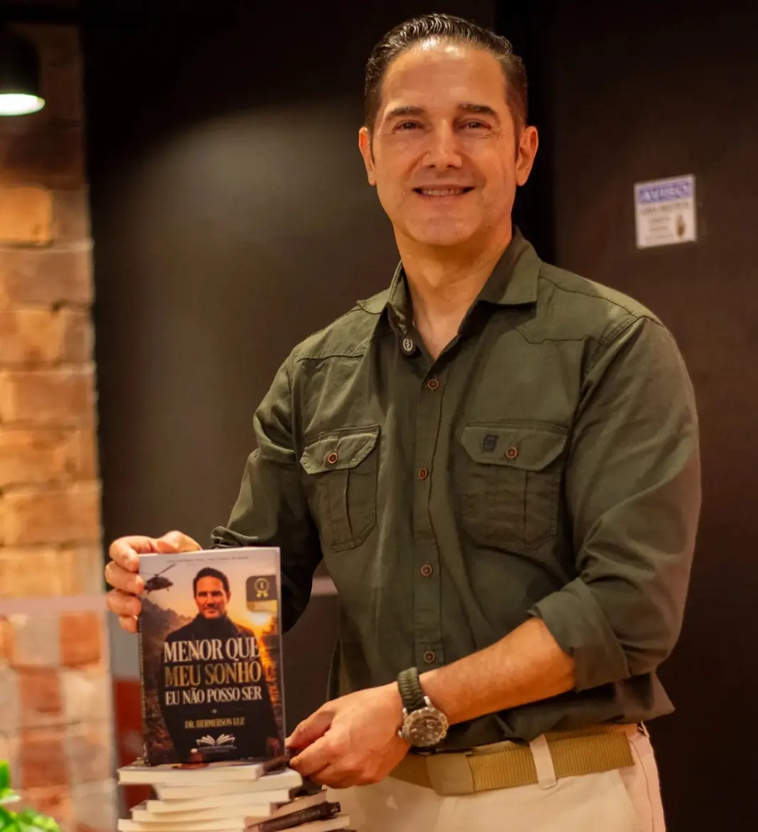 Autor segurando seu livro publicado em noite de autógrafos