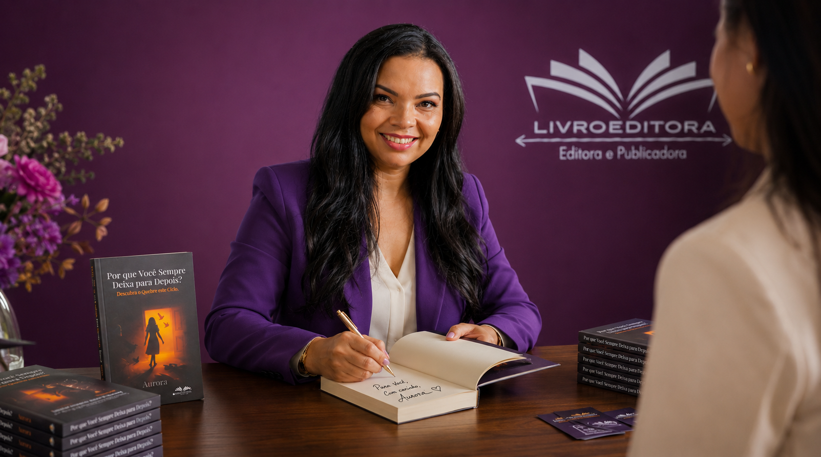 Autora emocionada segurando seu primeiro livro publicado